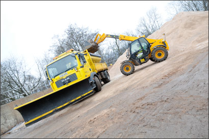 Image showing a front loader vehicle loading a gritter vehicle